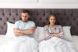 Young couple with relationship problems in bed at home